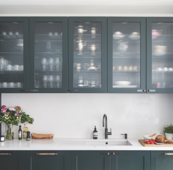 Dapur dengan lemari dapur dengan pintu kaca dan pencahayaan interior